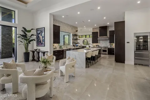 a kitchen with stainless steel appliances kitchen island granite countertop a refrigerator and a sink