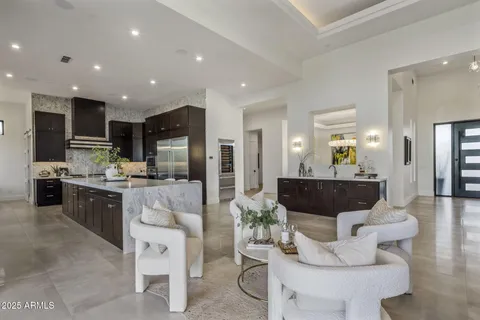 a living room with stainless steel appliances kitchen island granite countertop a couch and a view of living room