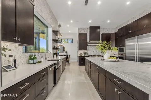 a large kitchen with stainless steel appliances kitchen island granite countertop a sink and cabinets