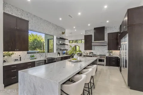 a large kitchen with kitchen island granite countertop a sink and stainless steel appliances