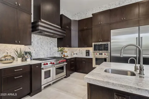 a kitchen with stainless steel appliances granite countertop a sink stove and cabinets