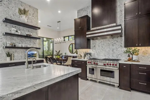 a kitchen with stainless steel appliances granite countertop a sink a stove and a wooden cabinets