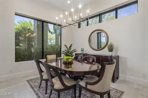 a dining room with furniture a chandelier and a rug