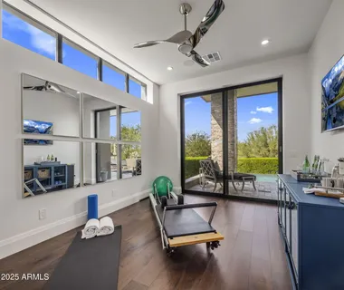 a living room with furniture gym equipment and a large window