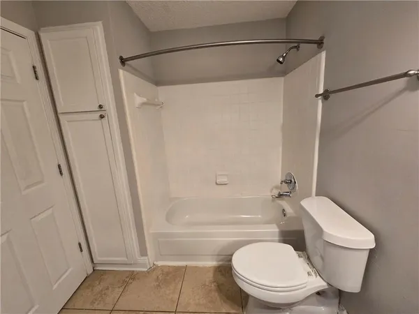 a bathroom with a toilet a mirror and bathtub