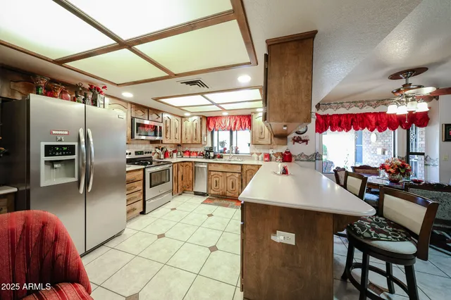 a kitchen with stainless steel appliances kitchen island granite countertop a table chairs in it and wooden floors