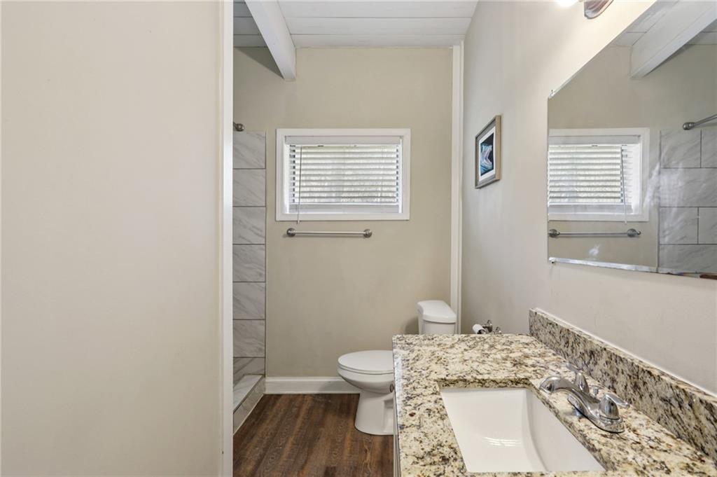 1291 Richard Road Decatur, GA 30032 - Photo 9 of 16 a bathroom with a granite countertop toilet a sink and a window