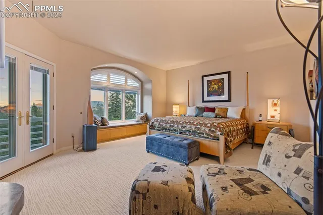 a bedroom with a bed and a large window