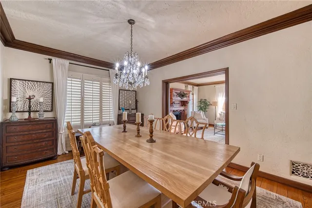 a dining room with furniture a chandelier and wooden floor