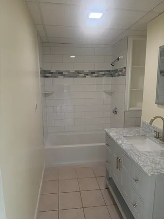 a bathroom with a granite countertop sink a toilet and shower
