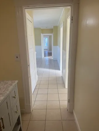 a view of a hallway and a livingroom with a bathroom