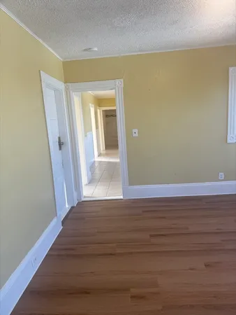 a view of a room with wooden floor and white walls
