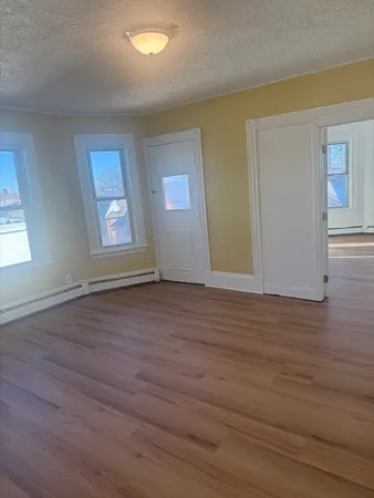 an empty room with wooden floor and windows
