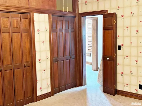 a view of a hallway with wooden floor and cabinet