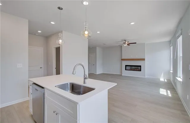 a kitchen with kitchen island a sink and a stove with wooden floor