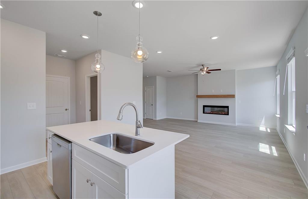 107 Alpine Road Fairburn, GA 30213 - Photo 11 of 22 a kitchen with kitchen island a sink and a stove with wooden floor