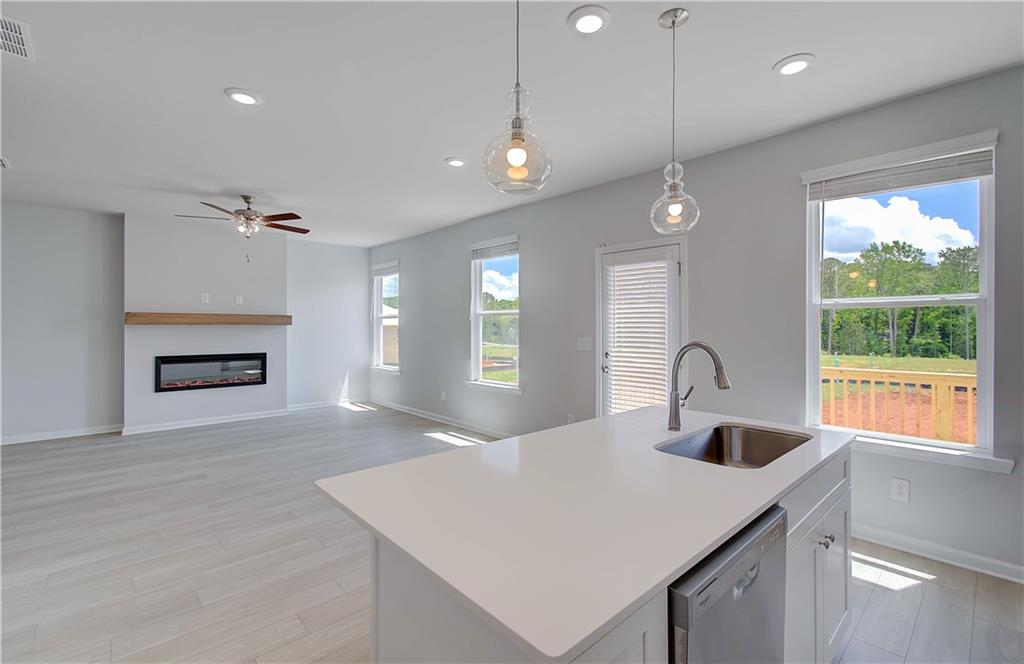 107 Alpine Road Fairburn, GA 30213 - Photo 12 of 22 a kitchen with a refrigerator a sink and a fireplace
