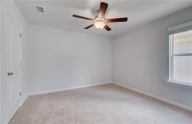 an empty room with a window and a fan