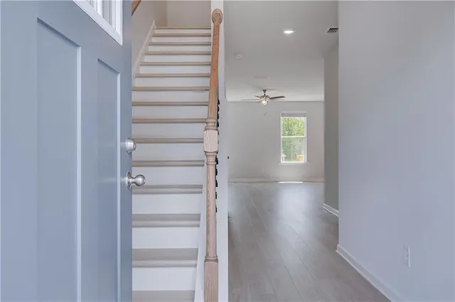 a view of a hallway with wooden floor and staircase