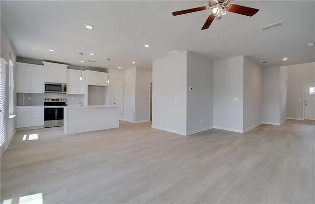 a view of kitchen with stainless steel appliances refrigerator and microwave