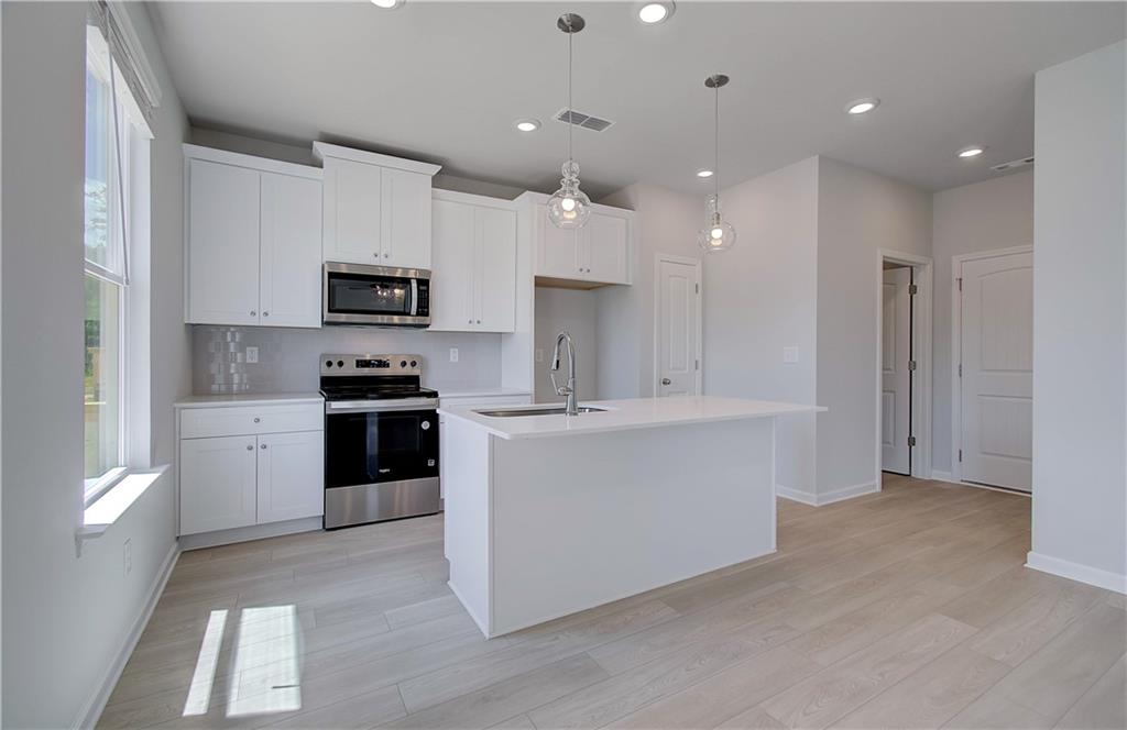 107 Alpine Road Fairburn, GA 30213 - Photo 10 of 22 a kitchen with kitchen island a sink stainless steel appliances and cabinets