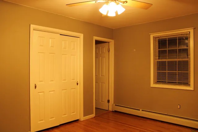 an empty room with wooden floor and a window