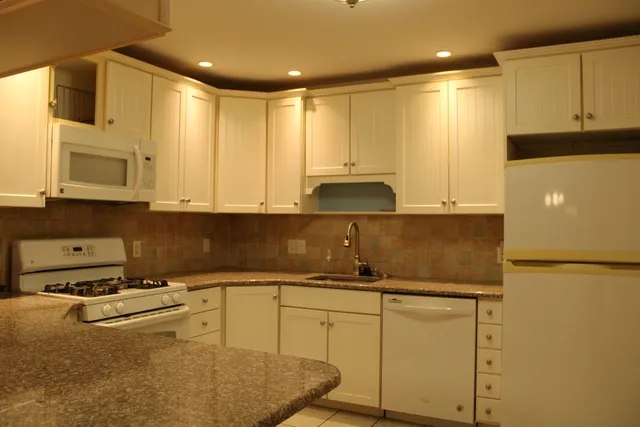 a kitchen with stainless steel appliances granite countertop a sink a stove and cabinets