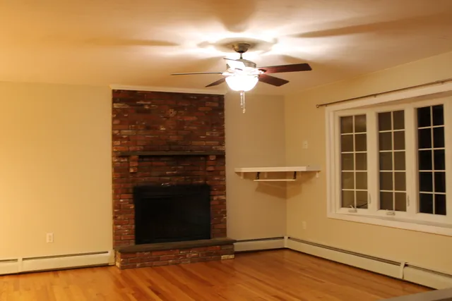a view of a livingroom with a fireplace and wooden floor