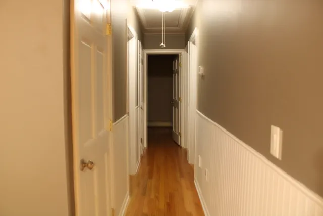 a view of a hallway with wooden floor and entryway