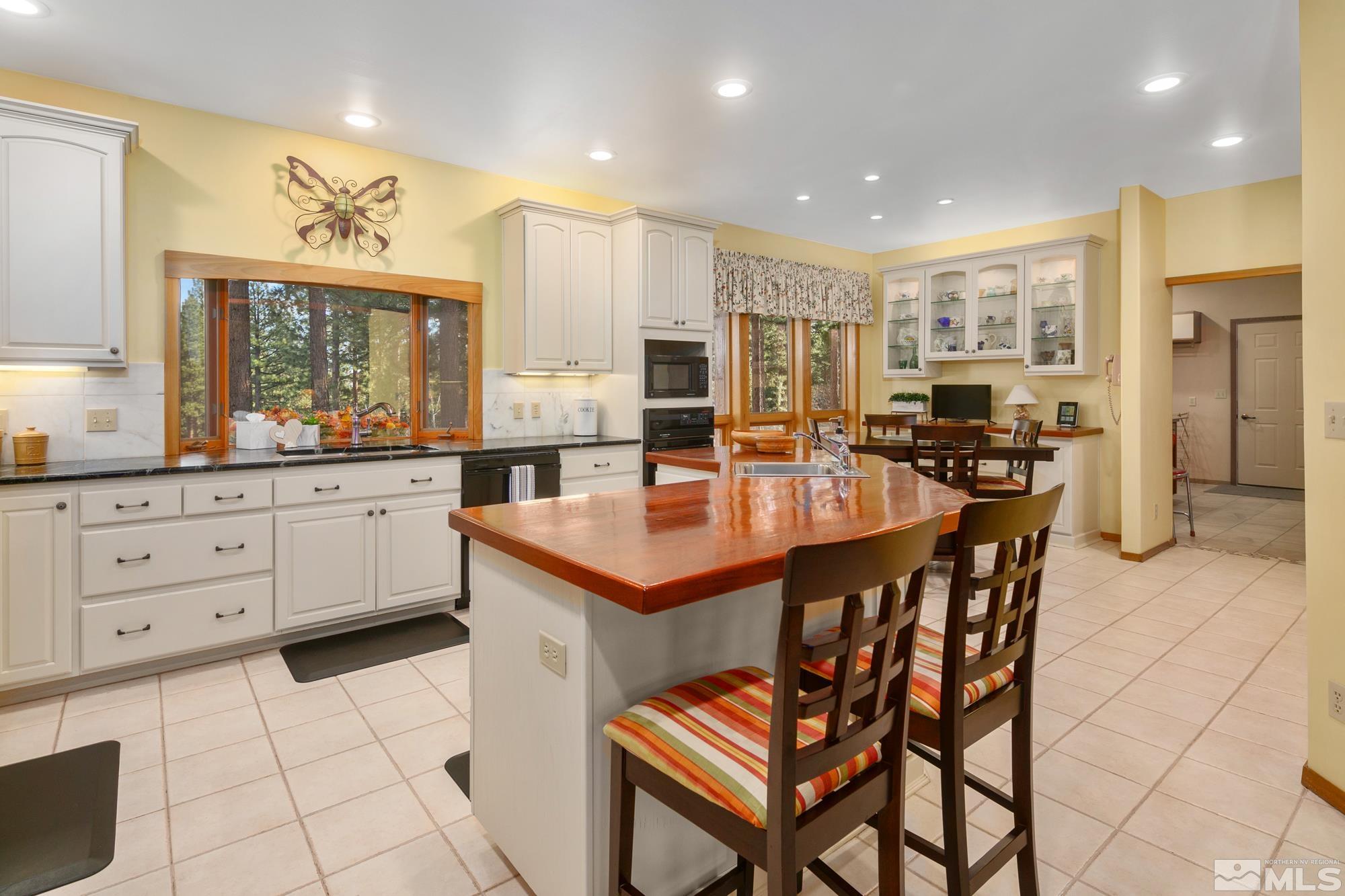 35 Austrian Pine Circle Reno, NV 89511 - Photo 7 of 39 a kitchen with stainless steel appliances kitchen island granite countertop a sink a stove a dining table and chairs