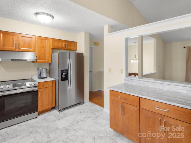 a kitchen with stainless steel appliances granite countertop a refrigerator and a sink