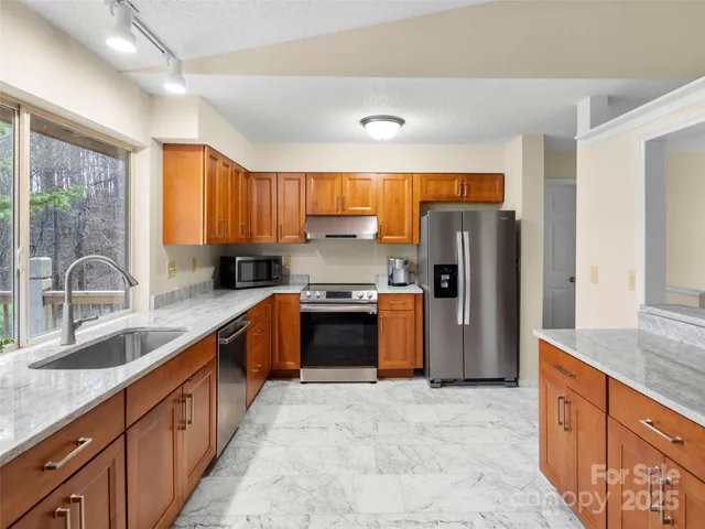 a kitchen with stainless steel appliances granite countertop a refrigerator and a sink