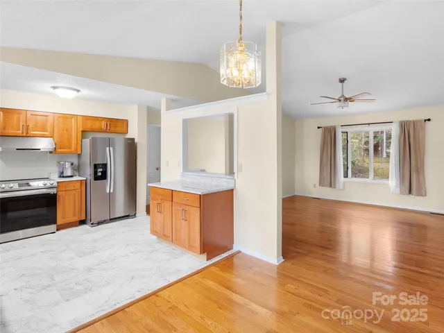 a kitchen with stainless steel appliances granite countertop a refrigerator a sink dishwasher stove and oven