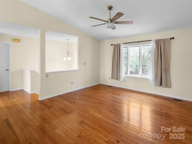 a view of a big room with wooden floor and windows
