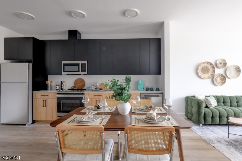 39 Madison Street Newark, NJ 07105 - Photo 16 of 33 a kitchen with stainless steel appliances kitchen island granite countertop a refrigerator a stove a sink a dining table and chairs with wooden floor