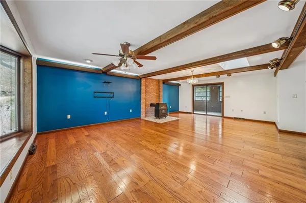 a view of a livingroom with wooden floor and a ceiling fan