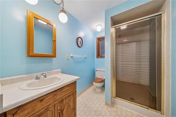 a bathroom with a sink a toilet and shower