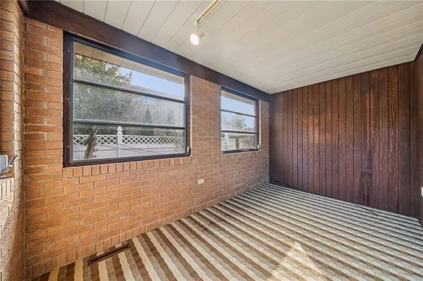 a view of a hallway with wooden floor and a window