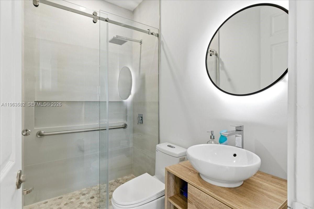 7743 Southwest 99th Street, Unit 2 Miami, FL 33156 - Photo 11 of 40 a bathroom with a toilet a sink and a mirror