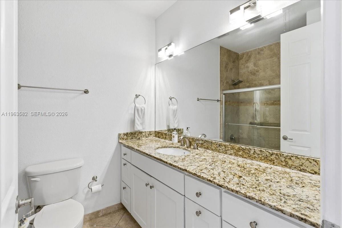 7743 Southwest 99th Street, Unit 2 Miami, FL 33156 - Photo 15 of 40 a bathroom with a granite countertop sink toilet and shower