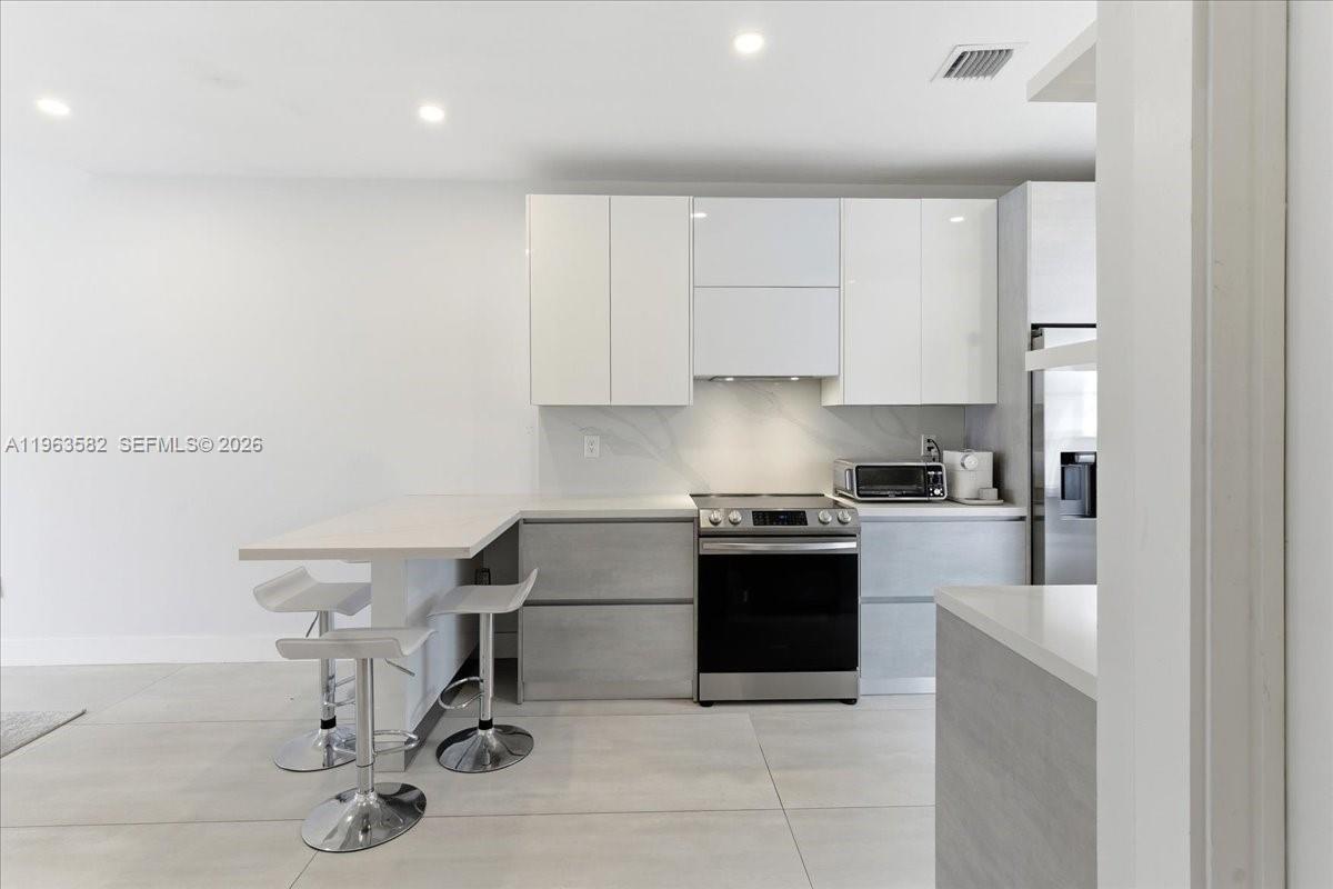 7743 Southwest 99th Street, Unit 2 Miami, FL 33156 - Photo 3 of 40 a kitchen with a sink cabinets and stainless steel appliances