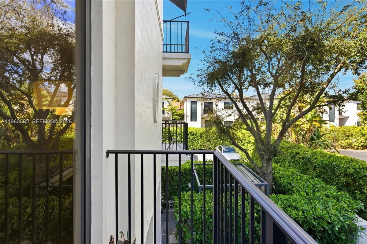 7743 Southwest 99th Street, Unit 2 Miami, FL 33156 - Photo 39 of 40 a balcony with wooden floor in front of house