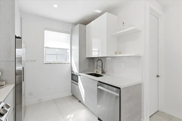 a kitchen with stainless steel appliances granite countertop a sink and a refrigerator