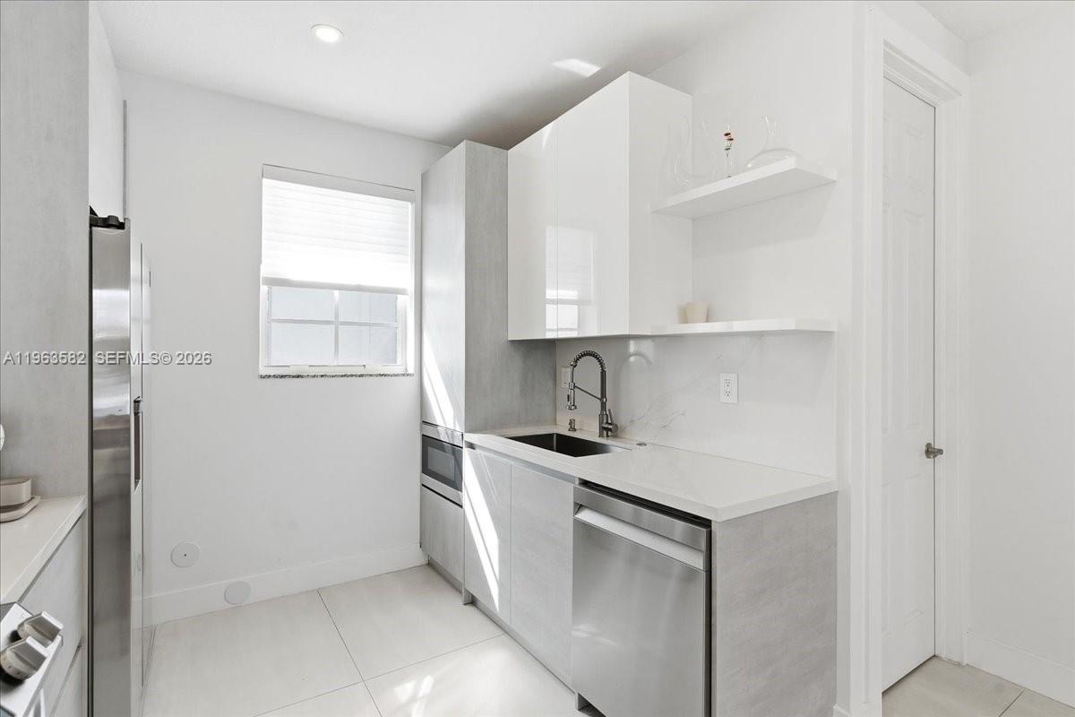 7743 Southwest 99th Street, Unit 2 Miami, FL 33156 - Photo 5 of 40 a kitchen with stainless steel appliances granite countertop a sink and a refrigerator