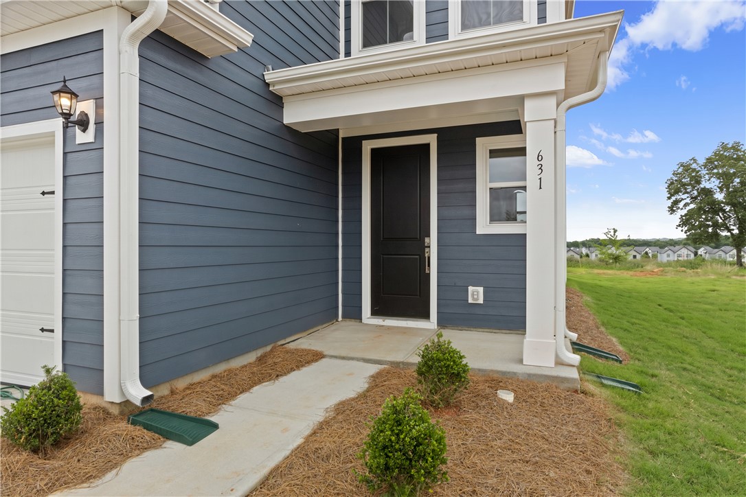 631 Sweetspire Trail, Unit 148 Seneca, SC 29678 - Photo 3 of 36 A welcoming front entrance, clad in deep blue siding, features a practical concrete walkway and neat landscaping.