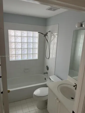 a bathroom with a granite countertop bathtub sink and toilet