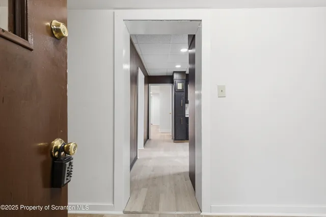 a view of a hallway with closet and a bathroom