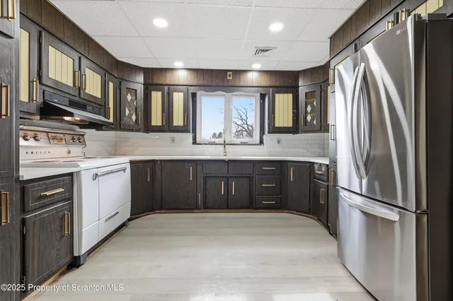 a kitchen with a refrigerator sink and cabinets