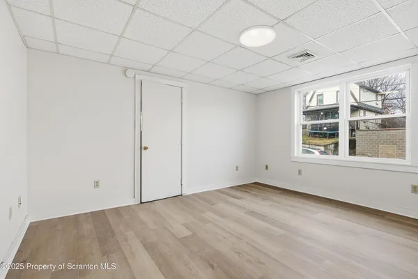 a view of empty room with wooden floor