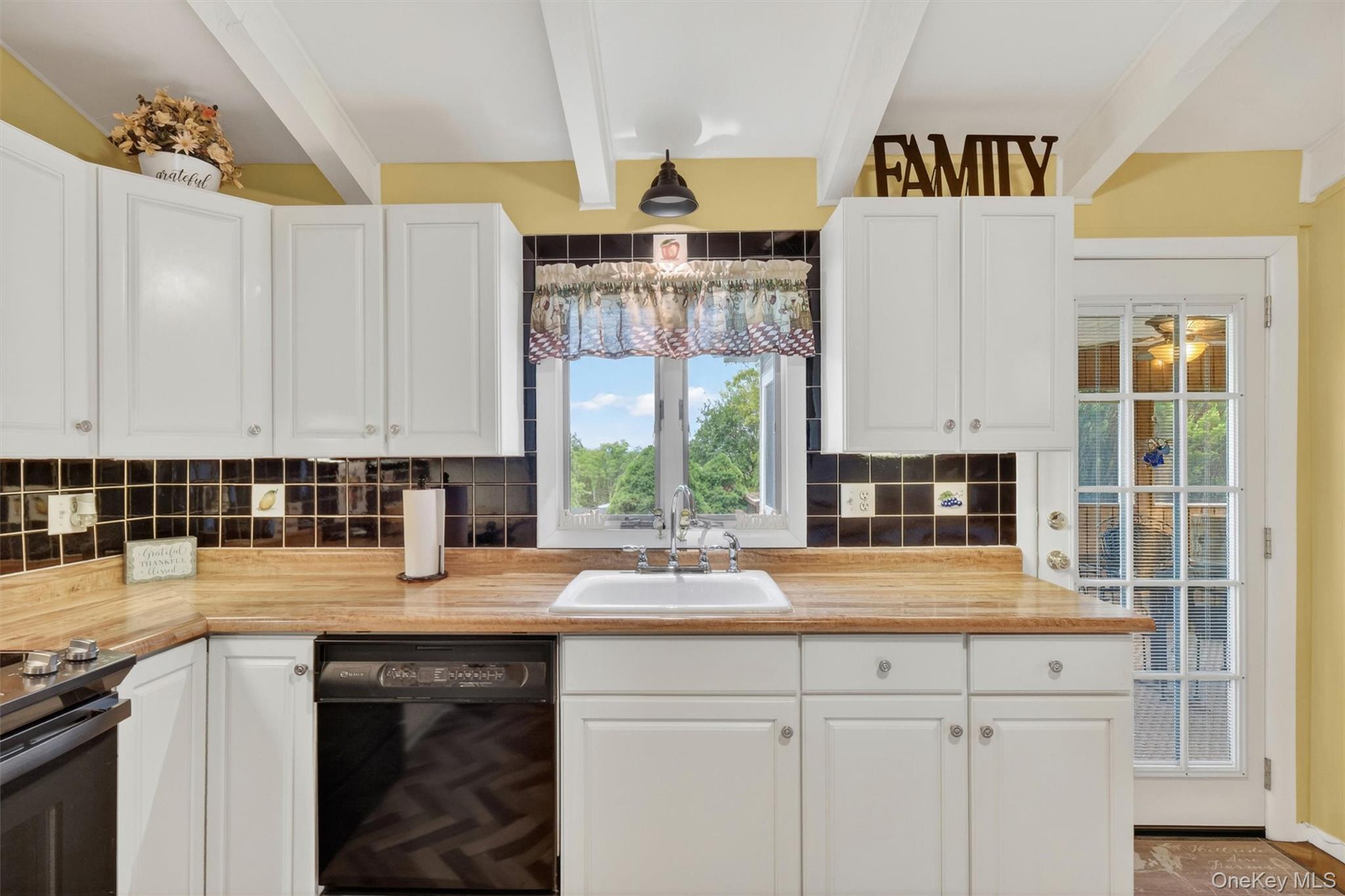 1 Rockledge Road Poughkeepsie, NY 12601 - Photo 15 of 36 Kitchen featuring vaulted ceilings with exposed beams, wood-finish flooring in a herringbone pattern, white cabinetry, breakfast bar, tile backsplash, cabinet lighting and light wood-finish countertops